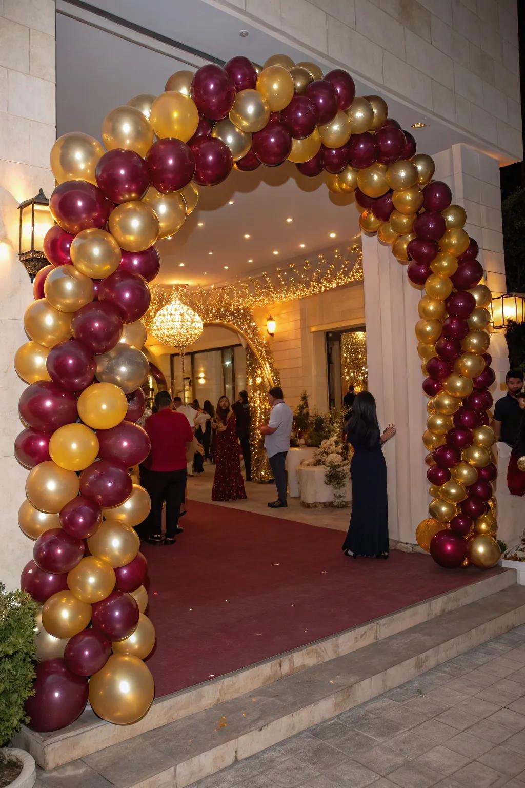 A stunning balloon arch in burgundy and gold welcomes guests with elegance.