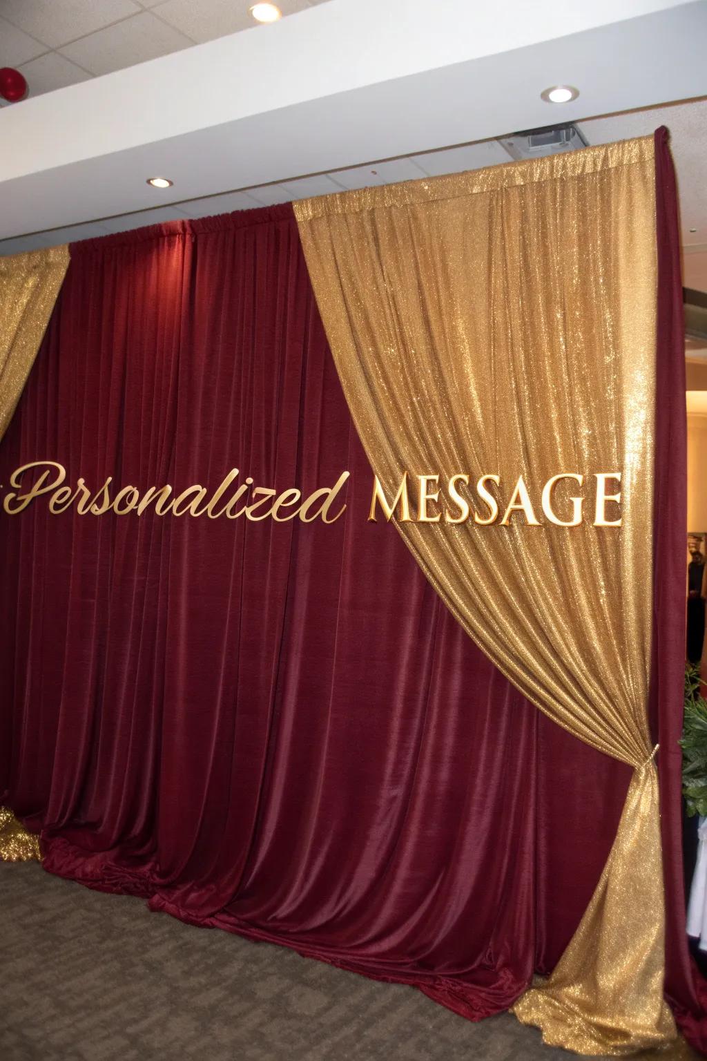 Create a focal point with luxurious burgundy and gold draped backdrops.