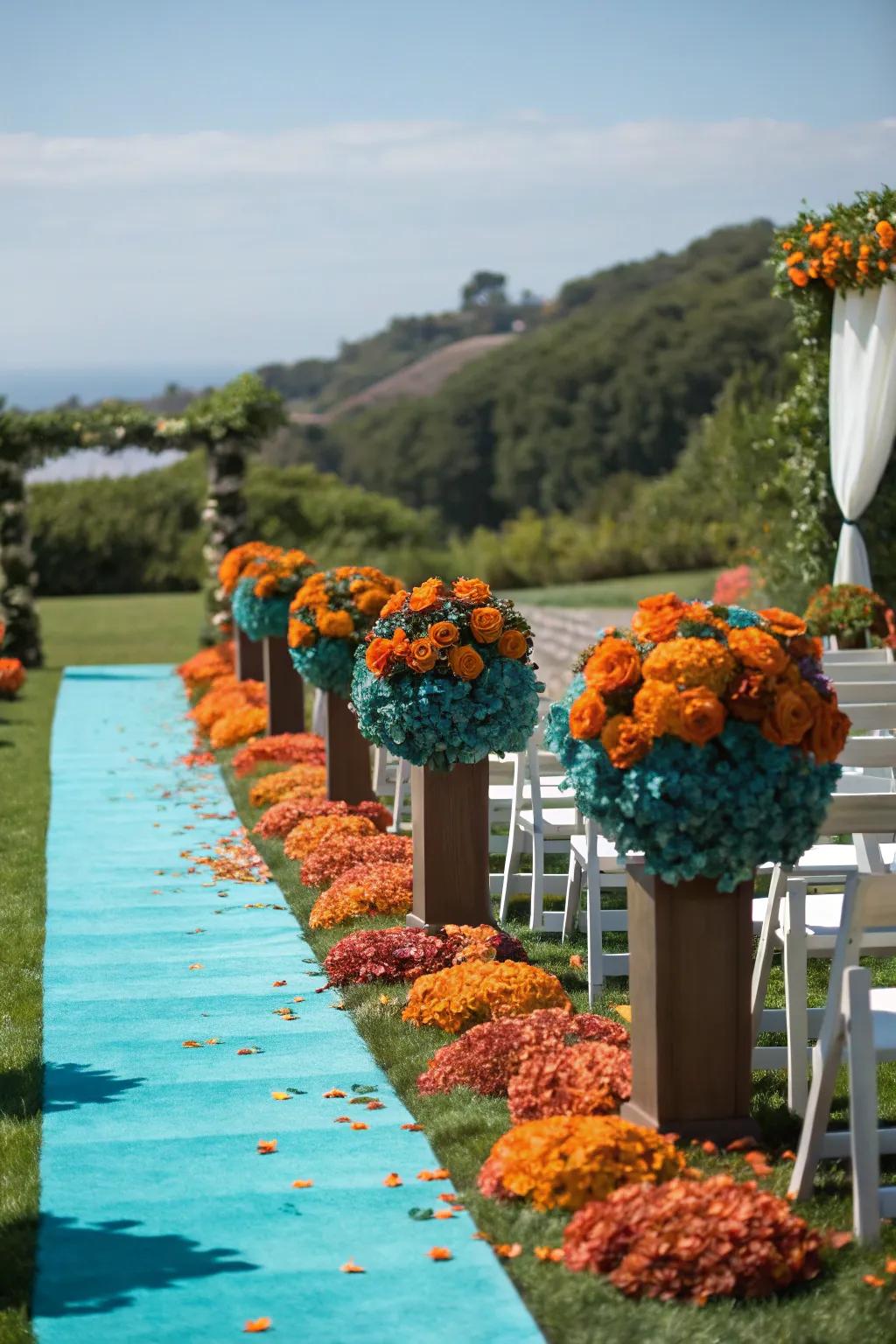 A wedding aisle adorned with teal and burnt orange flowers.