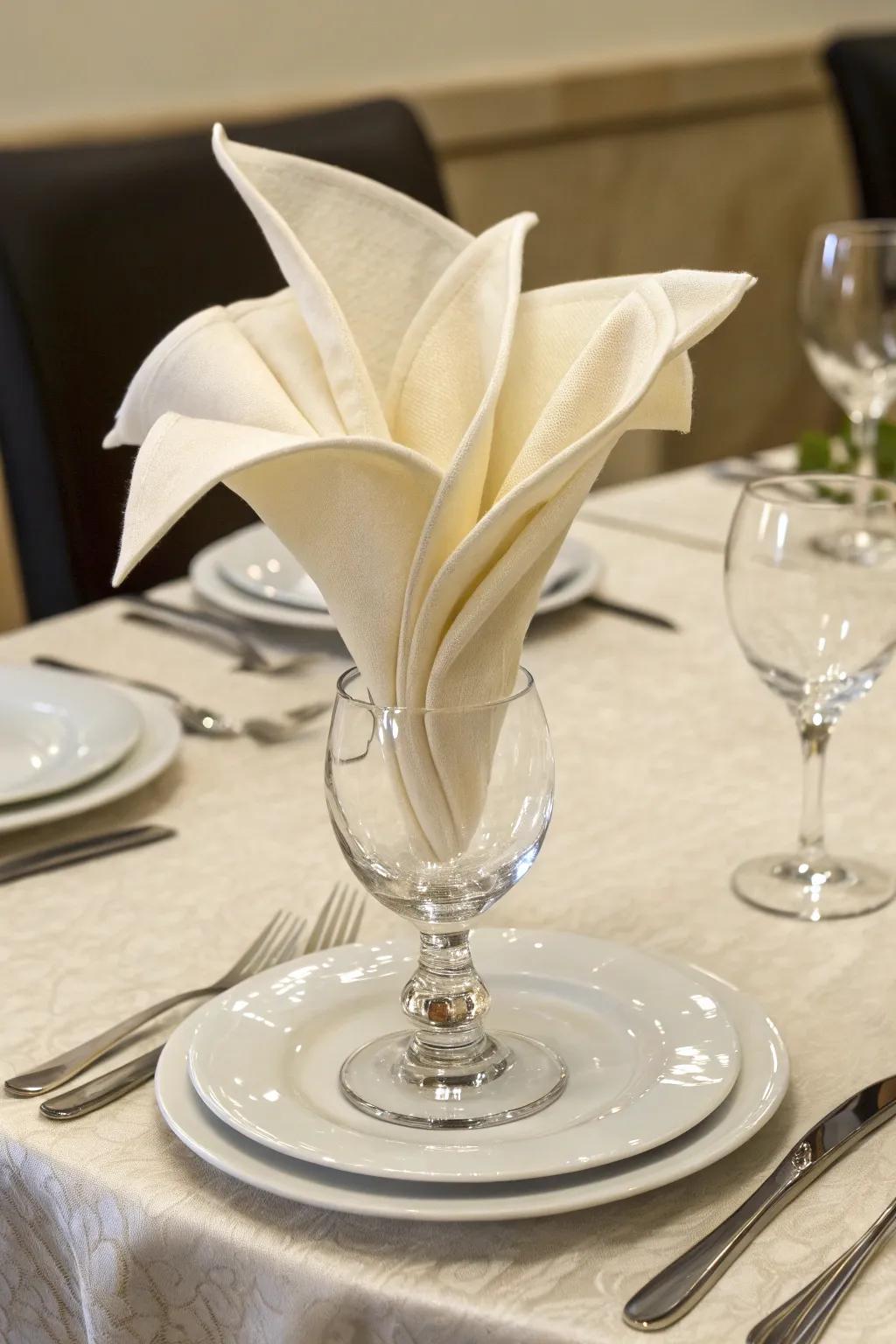 The lily bloom napkin fold introduces a floral detail to your setting.